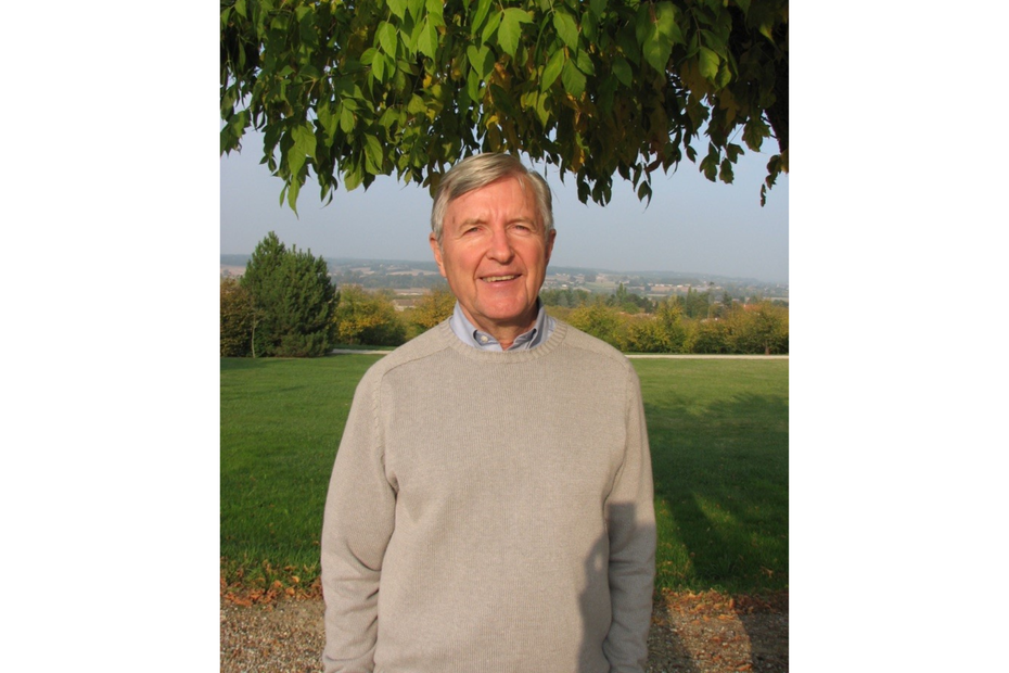 Michael Cooke smiles outside, surrounded by beautiful trees